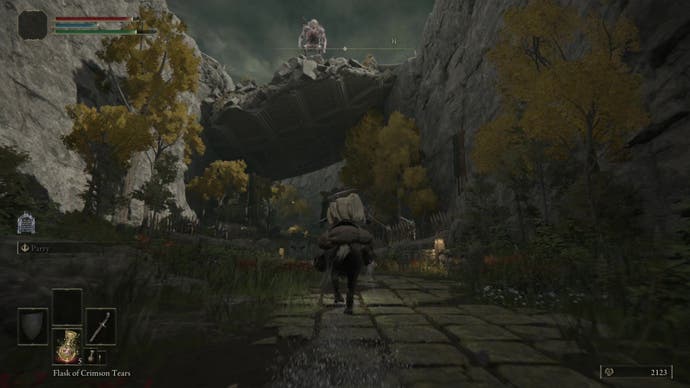 A cloaked figure in armor is mounted on a horse, passing beneath a makeshift bridge, while a troll looms above on the bridge.